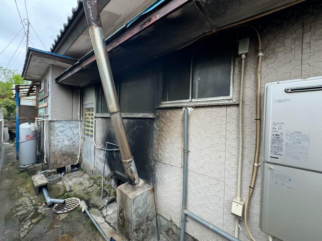 築約50年のお住まいは、かつて使用していた薪風呂の影響で外壁の煤（すす）汚れが目立っていました。