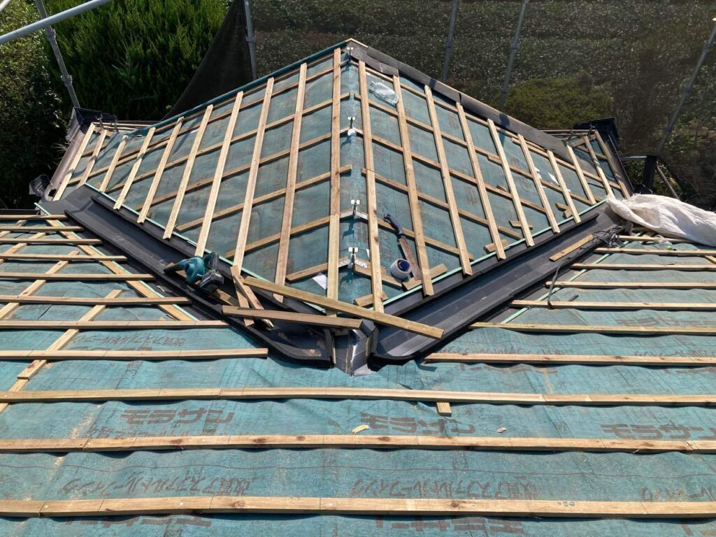 防水性を高めるため、平木の上に新たに防水シートを張りました。さらに、瓦を固定する木材（桟木）を取り付けます。