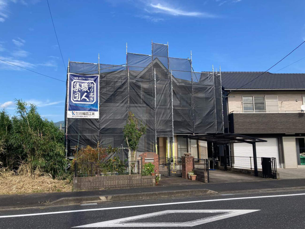 まずは安定した足場を立てます。養生シートをしっかりと張ることで、車や近隣への配慮を大切にしています。