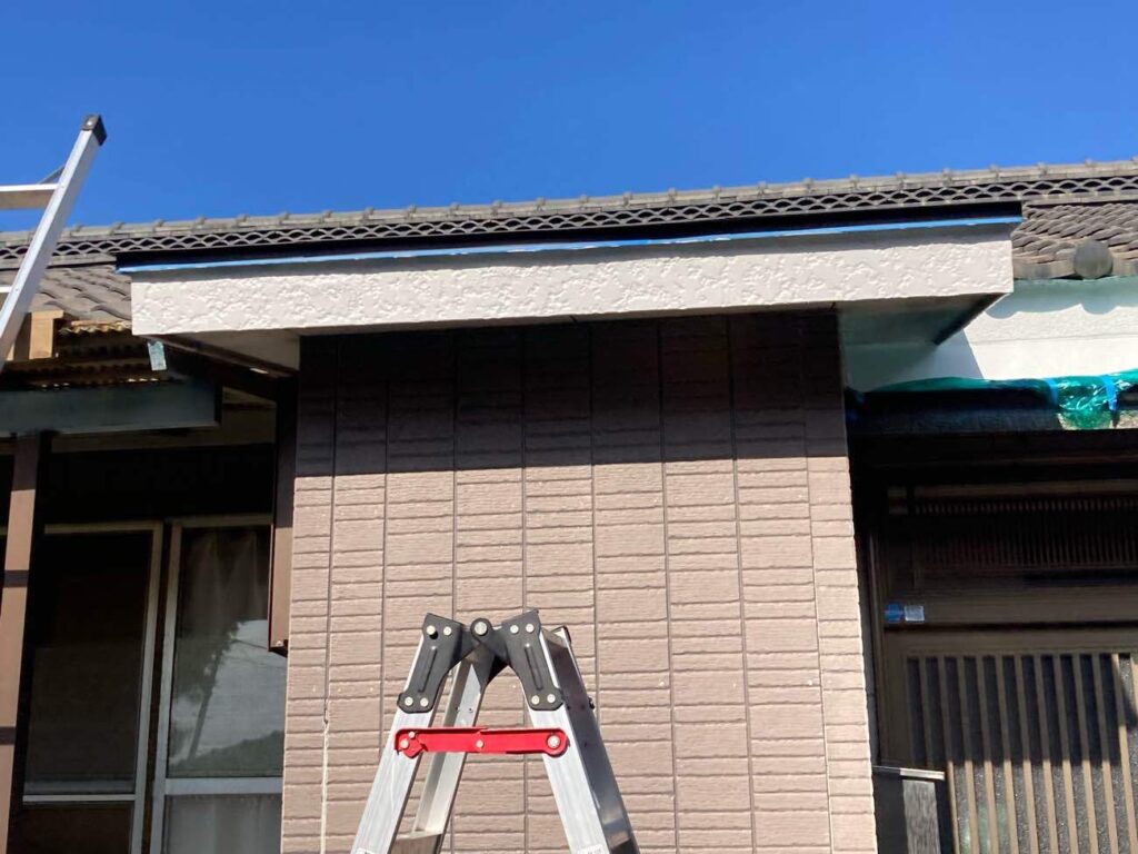 屋根下部のモルタル壁を塗装。玄関まわり全体の美観を整えるため、丁寧に仕上げていきます。