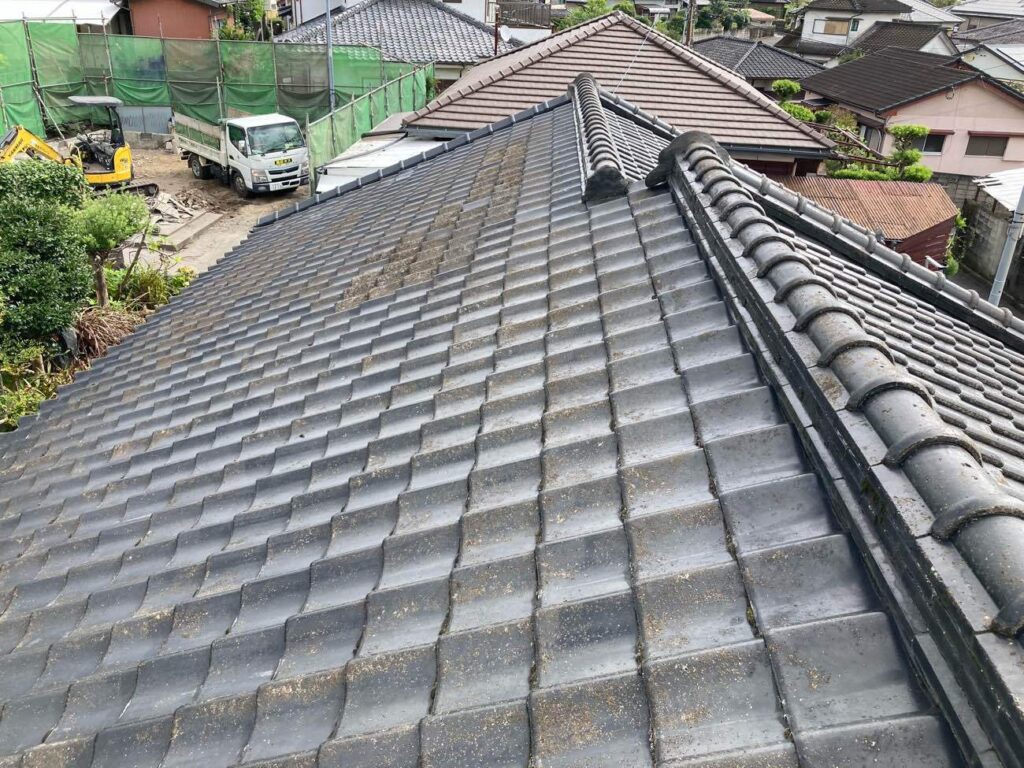 傷んだ箇所は部分的に修理されながら、大切に使われてきた瓦屋根。経年による色あせや苔の付着が見られ、全体的にメンテナンスの時期を迎えていました。