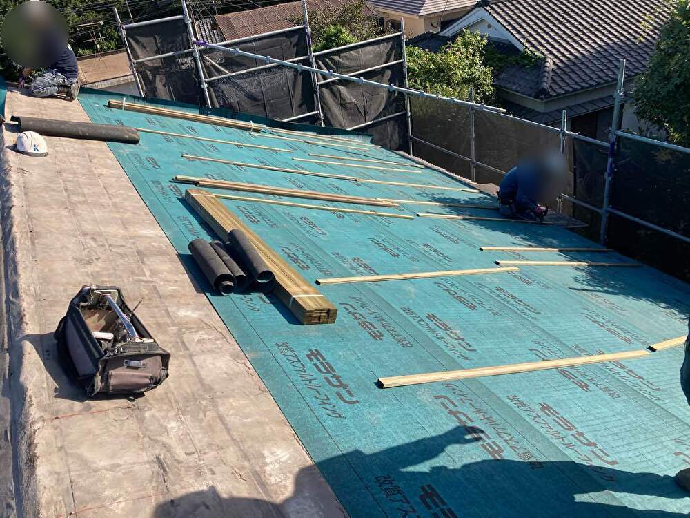 既存の防水シートに新しい防水シートを重ね、防水性がより高まるよう工夫しています。