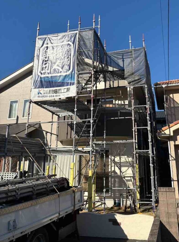 屋根工事を安全に進めるため、まずステージ足場を設置。2階ベランダから屋根へ上がれる動線を確保し、室内への出入りにも配慮した足場を組みました。