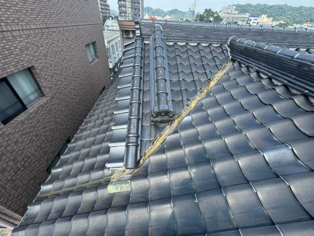 陶器瓦が葺かれた屋根を確認。瓦自体はまだ十分に使用できる状態でしたが、谷部分のセメント割れに加え、その先の瓦とつなぐ銅製板金にも腐食による穴あきがあり、雨漏りの原因となっていました。